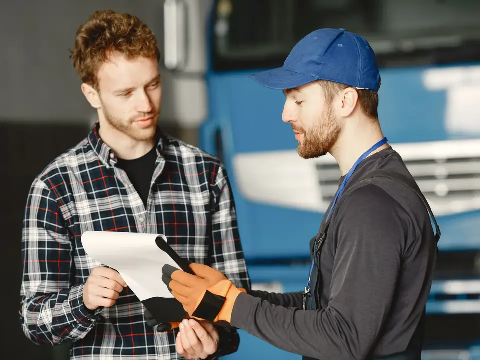 Mechanic explaining vehicle service findings to a customer in an auto repair shop